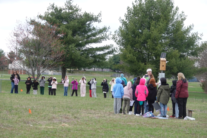 Students learning about the nestbox camera and how to use binoculars